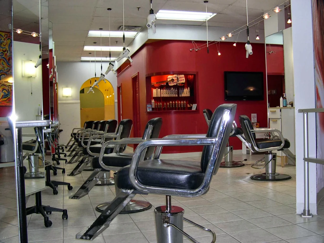 The salon floor with its signature red wall and styling chairs